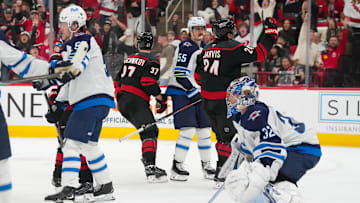 Nov 28, 2025; Raleigh, North Carolina, USA;  Carolina Hurricanes center Seth Jarvis (24) celebrates his goal past Winnipeg Jets goaltender Thomas Milic (32) and center Mark Scheifele (55) during the third period at Lenovo Center. Mandatory Credit: James Guillory-Imagn Images