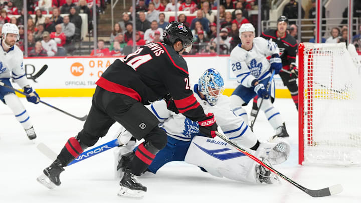 Dec 4, 2025; Raleigh, North Carolina, USA; Carolina Hurricanes center Seth Jarvis (24) tries to get the shot past Toronto Maple Leafs goaltender Joseph Woll (60) during the first period at Lenovo Center. Mandatory Credit: James Guillory-Imagn Images