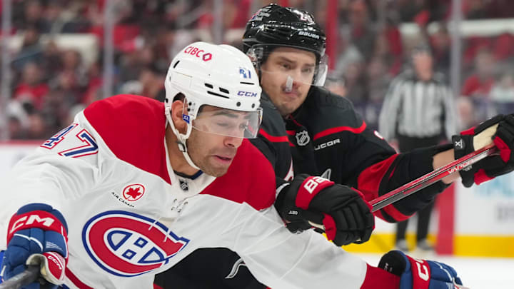 Jan 1, 2026; Raleigh, North Carolina, USA;  Carolina Hurricanes center Sebastian Aho (20) and Montréal Canadiens defenseman Jayden Struble (47) battle for position during the third period at Lenovo Center. Mandatory Credit: James Guillory-Imagn Images