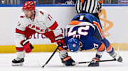 Apr 25, 2024; Elmont, New York, USA;  Carolina Hurricanes defenseman Tony DeAngelo (77) and New York Islanders left wing Anders Lee (27) collide during the second period in game three of the first round of the 2024 Stanley Cup Playoffs at UBS Arena. Mandatory Credit: Dennis Schneidler-Imagn Images