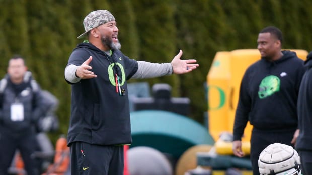 Oregon defensive line coach Tony Tuioti calls to players during a practice with the Ducks 