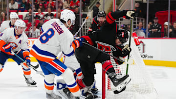 Dec 17, 2024; Raleigh, North Carolina, USA;  Carolina Hurricanes left wing William Carrier (28) is checked by New York Islanders defenseman Noah Dobson (8) during the third period at Lenovo Center. Mandatory Credit: James Guillory-Imagn Images