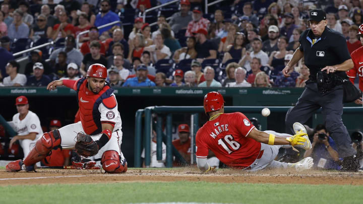 Jul 19, 2024; Washington, District of Columbia, USA; Cincinnati Reds third base Noelvi Marte (16) slides across home plate to score a run ahead of an attempted tag by Washington Nationals catcher Keibert Ruiz (20) during the ninth inning at Nationals Park. Mandatory Credit: Geoff Burke-USA TODAY Sports