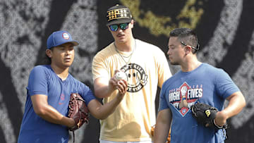 Aug 27, 2024; Pittsburgh, Pennsylvania, USA;  Chicago Cubs pitcher Shota Imanaga (left) and Pittsburgh Pirates pitcher Paul Skenes (middle) discuss pitching grips as Edwin Stanberry (right) interprets before the Pirates host the Cubs at PNC Park. Mandatory Credit: Charles LeClaire-Imagn Images