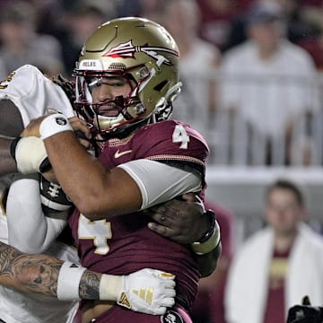 Sep 2, 2024; Tallahassee, Florida, USA; Florida State Seminoles quarterback DJ Uiagalelei (4) is tackled against the Boston College Eagles at Doak S. Campbell Stadium. Mandatory Credit: Melina Myers-Imagn Images