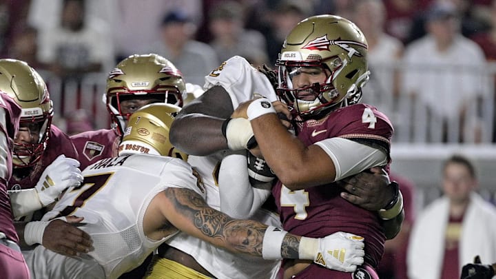 Sep 2, 2024; Tallahassee, Florida, USA; Florida State Seminoles quarterback DJ Uiagalelei (4) is tackled against the Boston College Eagles at Doak S. Campbell Stadium. Mandatory Credit: Melina Myers-Imagn Images