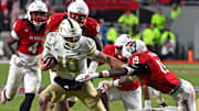 Nov 1, 2025; Raleigh, North Carolina, USA;  Georgia Tech Yellow Jackets quarterback Haynes King (10) controls the ball against North Carolina State Wolfpack safety Tristan Teasdell (19) during the fourth quarter at Carter-Finley Stadium. Mandatory Credit: Zachary Taft-Imagn Images