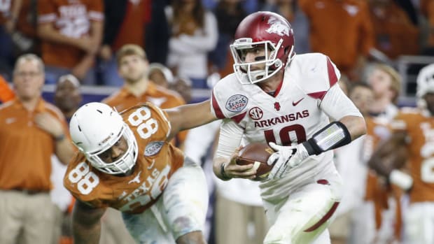 Dec 29, 2014; Houston, TX, USA; Arkansas Razorbacks quarterback Brandon Allen (10) runs past Texas Longhorns defensive end Ce