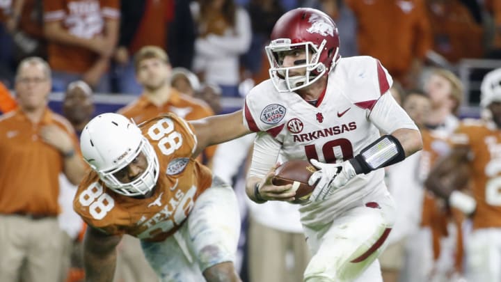 Dec 29, 2014; Houston, TX, USA; Arkansas Razorbacks quarterback Brandon Allen (10) runs past Texas Longhorns defensive end Cedric Reed (88) during the game in the 2014 Texas Bowl at NRG Stadium. Mandatory Credit: Kevin Jairaj-USA TODAY Sports