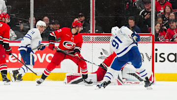 Apr 13, 2025; Raleigh, North Carolina, USA;  Toronto Maple Leafs center John Tavares (91) scores a goal past Carolina Hurricanes goaltender Frederik Andersen (31) and center Mark Jankowski (77) during the third period at Lenovo Center. Mandatory Credit: James Guillory-Imagn Images