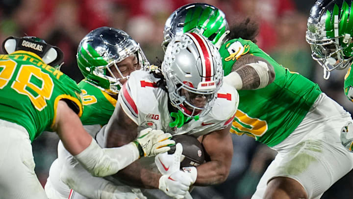 Ohio State Buckeyes running back Quinshon Judkins (1) runs through Oregon Ducks defensive end Matayo Uiagalelei (10) and linebacker Dylan Williams (20) during the College Football Playoff quarterfinal at the Rose Bowl in Pasadena, Calif. on Jan. 1, 2025.