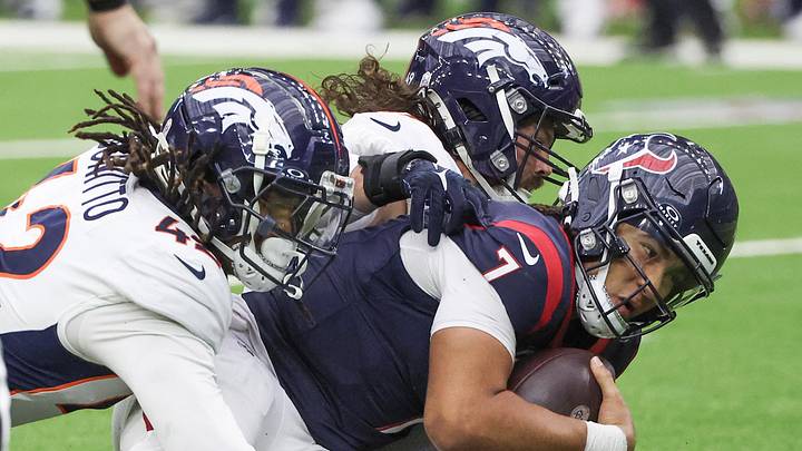 Dec 3, 2023; Houston, Texas, USA; Houston Texans quarterback C.J. Stroud (7) is sacked by Denver Broncos linebacker Alex Singleton (49) and linebacker Nik Bonitto (42) in the second half at NRG Stadium. Mandatory Credit: Thomas Shea-Imagn Images