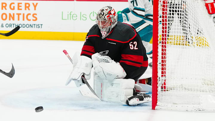 Dec 10, 2024; Raleigh, North Carolina, USA;  Carolina Hurricanes goaltender Pyotr Kochetkov (52) clears the puck away against the San Jose Sharks during the second period at Lenovo Center. Mandatory Credit: James Guillory-Imagn Images