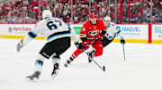 Feb 8, 2025; Raleigh, North Carolina, USA;  Carolina Hurricanes defenseman Scott Morrow (56) skates with the puck in between right wing Josh Doan (91) and y67 during the first period at Lenovo Center. Mandatory Credit: James Guillory-Imagn Images