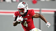 Nov 1, 2025; Raleigh, North Carolina, USA;  North Carolina State Wolfpack running back Jayden Scott (4) runs the ball around Georgia Tech Yellow Jackets linebacker E.J. Lightsey (2) during the first quarter at Carter-Finley Stadium. Mandatory Credit: Zachary Taft-Imagn Images