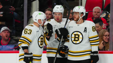 Apr 4, 2024; Raleigh, North Carolina, USA; Boston Bruins left wing Brad Marchand (63) defenseman Charlie McAvoy (73) and right wing David Pastrnak (88) talk against the Carolina Hurricanes during the second period at PNC Arena. Mandatory Credit: James Guillory-USA TODAY Sports