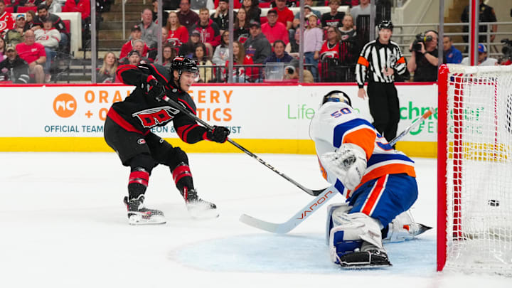 Mar 30, 2025; Raleigh, North Carolina, USA;  Carolina Hurricanes center Mark Jankowski (77) scores a goal past New York Islanders goaltender Marcus Hogberg (50) during the first period at Lenovo Center. Mandatory Credit: James Guillory-Imagn Images