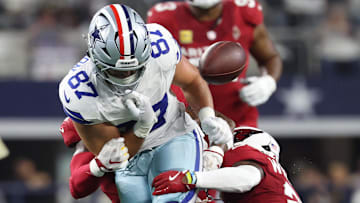 Nov 3, 2025; Arlington, Texas, USA; Dallas Cowboys tight end Jake Ferguson (87) fumbles against Arizona Cardinals linebacker Mack Wilson Sr. (2) and cornerback Garrett Williams (21) in the first half at AT&T Stadium.