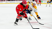 Mar 25, 2025; Raleigh, North Carolina, USA;  Carolina Hurricanes defenseman Jalen Chatfield (5) skates with the puck outside of Nashville Predators defenseman Brady Skjei (76) during the third period at Lenovo Center. Mandatory Credit: James Guillory-Imagn Images