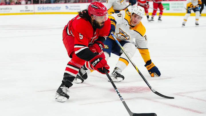 Mar 25, 2025; Raleigh, North Carolina, USA; Carolina Hurricanes defenseman Jalen Chatfield (5) skates with the puck outside of Nashville Predators defenseman Brady Skjei (76) during the third period at Lenovo Center. Mandatory Credit: James Guillory-Imagn Images Mar 25, 2025; Raleigh, North Carolina, USA; Carolina Hurricanes defenseman Jalen Chatfield (5) skates with the puck outside of Nashville Predators defenseman Brady Skjei (76) during the third period at Lenovo Center. Mandatory Credit: James Guillory-Imagn Images