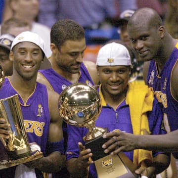 June 12, 2002; East Rutherford, NJ, USA;  (left to right) Los Angeles Lakers Kobe Bryant,  Lindsay Hunter and Shaquille O'Neal hold championship trophies after winning Game 4 of the NBA Finals at The Meadowlands. Mandatory Credit: Robert Deutsch-Imagn Images
