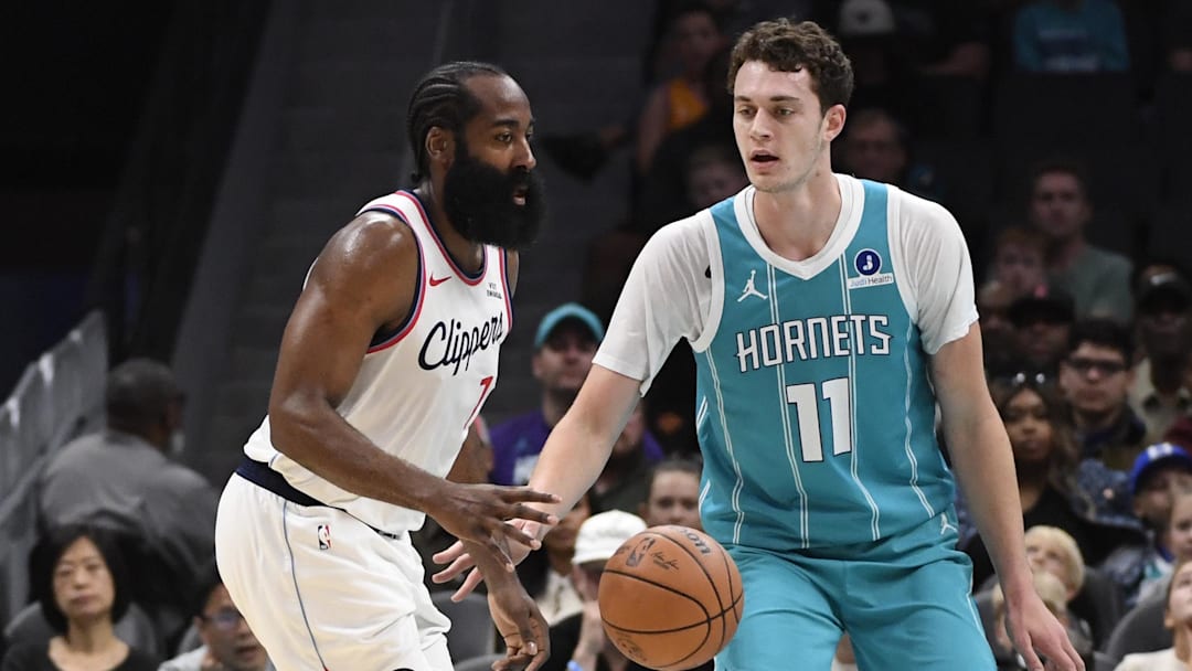 Nov 22, 2025; Charlotte, North Carolina, USA; Los Angeles Clippers guard James Harden (1) dribbles past Charlotte Hornets center Ryan Kalkbrenner (11) during the first half at the Spectrum Center. Mandatory Credit: Sam Sharpe-Imagn Images