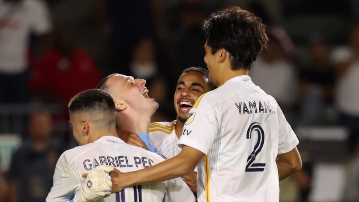 Aug 4, 2024; Carson, California, USA;  Los Angeles Galaxy goalkeeper Novak Micovic (35) celebrates with forward Gabriel Pec (11) and defender Jalen Neal (24) and defender Miki Yamane (2) after making a save on a penalty kick to win a penalty kick shoot out against the Chivas Guadalajara at Dignity Health Sports Park. Mandatory Credit: Kiyoshi Mio-USA TODAY Sports