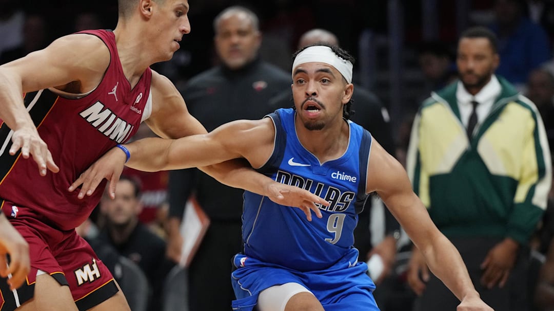 Nov 24, 2025; Miami, Florida, USA; Dallas Mavericks guard Ryan Nembhard (9) drives past Miami Heat forward Simone Fontecchio (0) during the second half at Kaseya Center. Mandatory Credit: Jim Rassol-Imagn Images