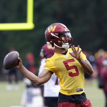 Jul 26, 2024; Ashburn, VA, USA; Washington Commanders quarterback Jayden Daniels (5) passes the ball on day three of training camp at Commanders Park. Mandatory Credit: Geoff Burke-USA TODAY Sports