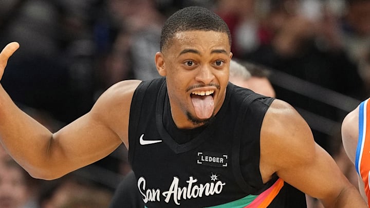 Dec 23, 2025; San Antonio, Texas, USA; San Antonio Spurs forward Keldon Johnson (3) reacts after scoring a three point basket ahead of Oklahoma City Thunder guard Alex Caruso (9) during the second half at Frost Bank Center. Mandatory Credit: Scott Wachter-Imagn Images