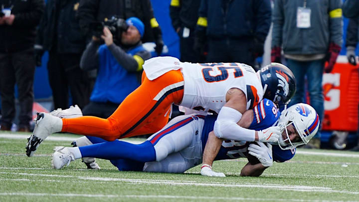 Denver Broncos linebacker Cody Barton tackles Buffalo Bills tight end Dalton Kincaid/