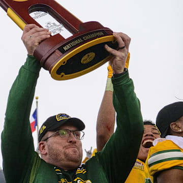 Jan 8, 2022; Frisco, TX, USA; North Dakota State Bison head coach Matt Entz holds up the championship trophy as the North Dakota State Bison team celebrates the win over the Montana State Bobcats in the FCS Championship at Toyota Stadium. Mandatory Credit: Jerome Miron-Imagn Images