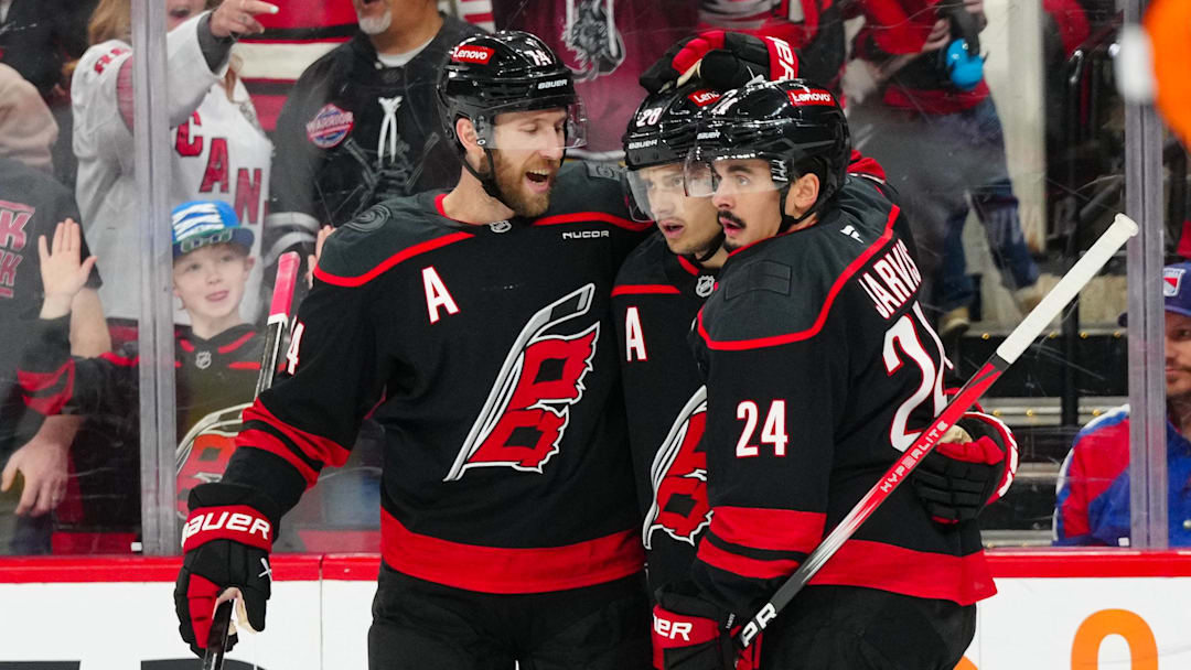 Apr 12, 2025; Raleigh, North Carolina, USA;  Carolina Hurricanes center Seth Jarvis (24) is congratulated by  center Sebastian Aho (20) and defenseman Jaccob Slavin (74) after his goal against the New York Rangers during the first period at Lenovo Center. Mandatory Credit: James Guillory-Imagn Images