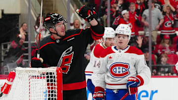 Mar 28, 2025; Raleigh, North Carolina, USA;  Carolina Hurricanes right wing Andrei Svechnikov (37) scores an empty net goal past Montreal Canadiens right wing Cole Caufield (13) during the third period at Lenovo Center. Mandatory Credit: James Guillory-Imagn Images