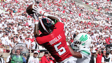 Sep 14, 2024; Lubbock, Texas, USA;  Texas Tech Red Raiders wide receiver Caleb Douglas (5) battles for a pass against North Texas Mean Green defensive safety Taylor Starling (17) in the first half at Jones AT&T Stadium and Cody Campbell Field. Mandatory Credit: Michael C. Johnson-Imagn Images