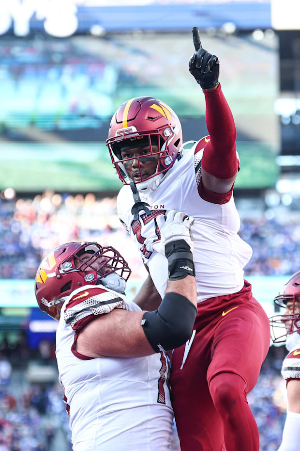 Washington Commanders wide receiver Terry McLaurin celebrates after a touchdown reception with guard Sam Cosmi