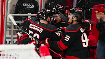 Mar 9, 2025; Raleigh, North Carolina, USA;  Carolina Hurricanes center Mark Jankowski (77) is congratulated after his goal by center Jack Roslovic (96) and defenseman Scott Morrow (56) against the Winnipeg Jets during the first period at Lenovo Center. Mandatory Credit: James Guillory-Imagn Images