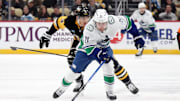 Nov 27, 2024; Pittsburgh, Pennsylvania, USA;  Vancouver Canucks left wing Nils Hoglander (21) chases the puck ahead of Pittsburgh Penguins defenseman Jack St. Ivany (3) during the second period at PPG Paints Arena. Mandatory Credit: Charles LeClaire-Imagn Images