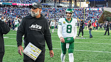 Aaron Rodgers and interim head coach Jeff Ulbrich exit the field after losing to the Patriots.