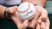 A young Texas fans holds a ball in hope of autographs as the Longhorns prepare to take on the Florida Gators in Austin, May 10, 2025.