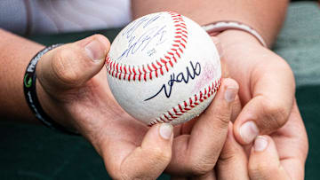 A young Texas fans holds a ball in hope of autographs as the Longhorns prepare to take on the Florida Gators in Austin, May 10, 2025.