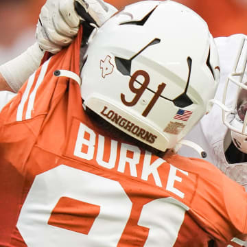 April 20, 2024; Austin, Texas, USA: Texas White team offensive lineman Cameron Williams (56) grabs the uniform of Texas Orange team edge Ethan Burke (91) in the second quarter of the Longhorns' spring Orange and White game at Darrell K Royal Texas Memorial Stadium. Mandatory Credit: Sara Diggins-USA Today Sports via American Statesman