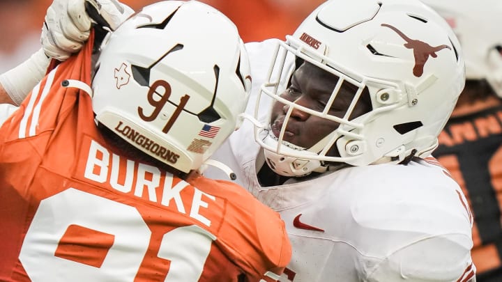 April 20, 2024; Austin, Texas, USA: Texas White team offensive lineman Cameron Williams (56) grabs the uniform of Texas Orange team edge Ethan Burke (91) in the second quarter of the Longhorns' spring Orange and White game at Darrell K Royal Texas Memorial Stadium. Mandatory Credit: Sara Diggins-USA Today Sports via American Statesman