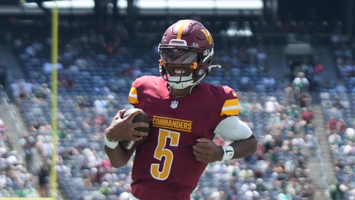 Aug 10, 2024; East Rutherford, New Jersey, USA; Washington Commanders quarterback Jayden Daniels (5) rushes for a touchdown during the first quarter against the New York Jets at MetLife Stadium. Mandatory Credit: Lucas Boland-USA TODAY Sports