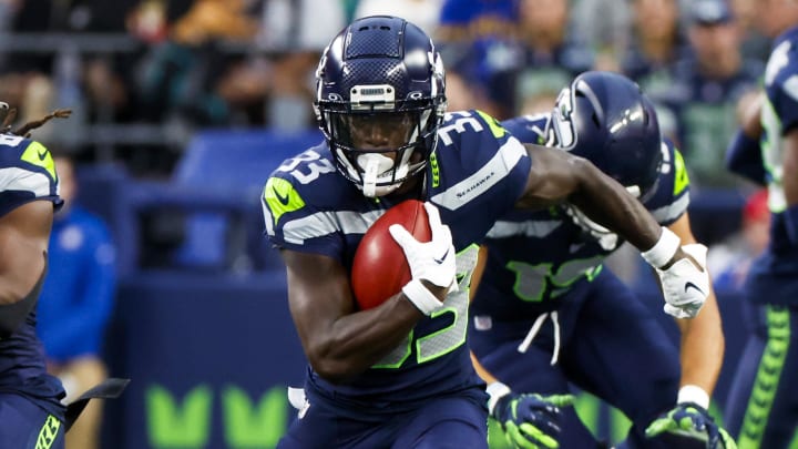 Aug 24, 2024; Seattle, Washington, USA; Seattle Seahawks wide receiver Dee Williams (33) returns a punt against the Cleveland Browns during the first quarter at Lumen Field. Seattle Seahawks cornerback Devon Witherspoon (21) blocks at left. Mandatory Credit: Joe Nicholson-USA TODAY Sports