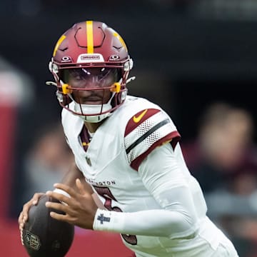 Sep 29, 2024; Glendale, Arizona, USA; Washington Commanders quarterback Jayden Daniels (5) runs the ball against the Arizona Cardinals in the first half at State Farm Stadium. Mandatory Credit: Mark J. Rebilas-Imagn Images