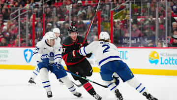 Jan 9, 2025; Raleigh, North Carolina, USA;  Carolina Hurricanes right wing Andrei Svechnikov (37) goes after the puck against Toronto Maple Leafs defenseman Simon Benoit (2) and right wing Pontus Holmberg (29) during the third period at Lenovo Center. Mandatory Credit: James Guillory-Imagn Images