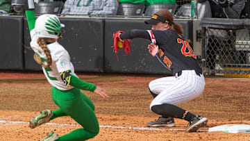 Oregon's Kai Luschar, left, tries to make it to third on an error throw ahead the tag by Maryland's Michaela Jones during the Jane Sanders Classic at Jane Sanders Stadium Saturday, March 2, 2024