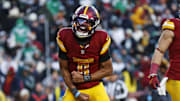 Dec 22, 2024; Landover, Maryland, USA; Washington Commanders quarterback Jayden Daniels (5) celebrates after throwing the game winning touchdown during the fourth quarter against the Philadelphia Eagles at Northwest Stadium. Mandatory Credit: Peter Casey-Imagn Images