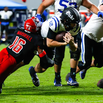 Nov 9, 2024; Raleigh, North Carolina, USA; North Carolina State Wolfpack cornerback Devon Marshall (16) tackles Duke Blue Devils quarterback Grayson Loftis (12) during the second half of the game at Carter-Finley Stadium. Mandatory Credit: Jaylynn Nash-Imagn Images